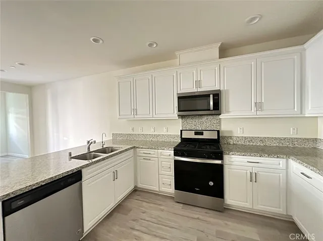 a kitchen with a sink and steel appliances