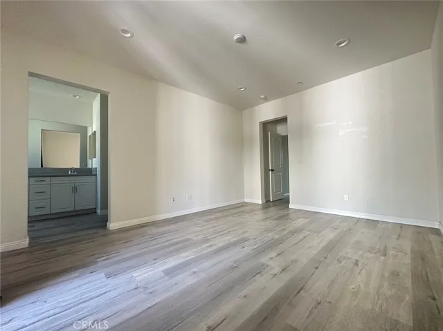 wooden floor in an empty room with wooden floor and a bathroom