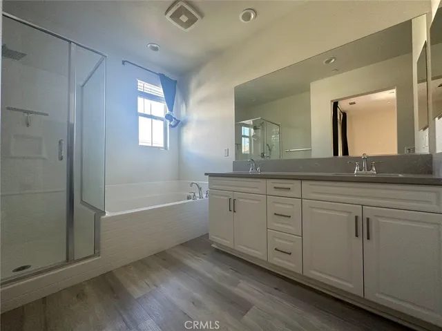a spacious bathroom with a granite countertop sink mirror and bathtub