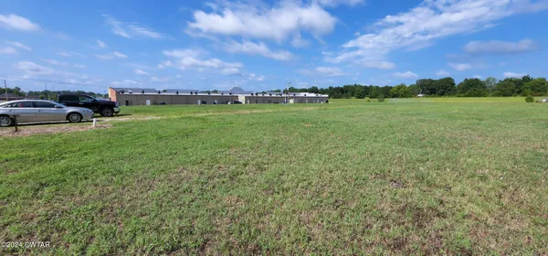 a view of a field of grass and trees
