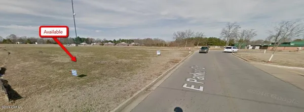 a view of a big yard with a house in the background