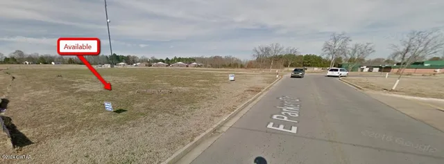 a view of a big yard with a house in the background
