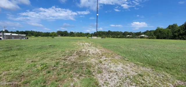 a view of a field and trees in the background