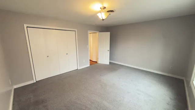 an empty room with a ceiling fan and a window