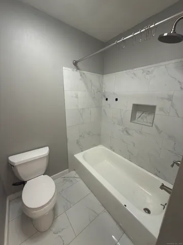 a bathroom with a toilet and bathtub