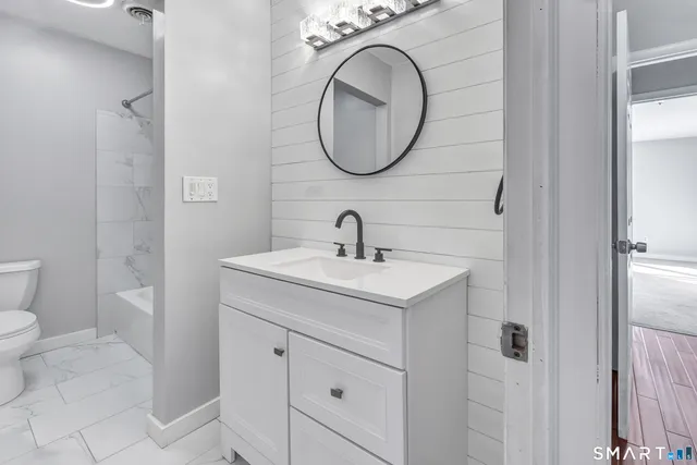 a bathroom with a sink a toilet and a mirror