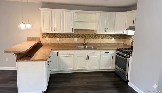a kitchen with granite countertop a sink and a stove