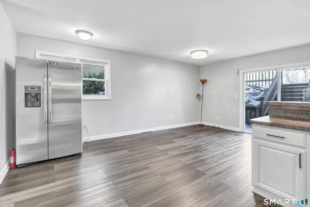 a view of a kitchen with wooden floor electronic appliances and windows