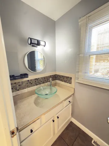 a bathroom with a granite countertop sink and a mirror