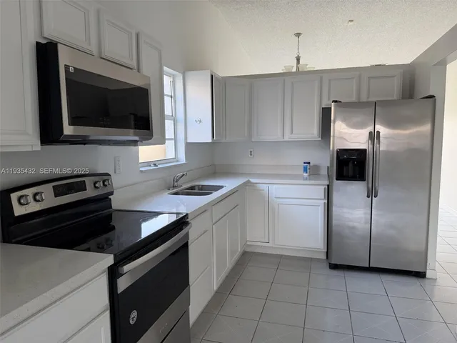 a kitchen with a sink stainless steel appliances and cabinets