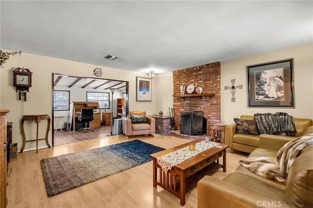 a living room with furniture a fireplace and wooden floor