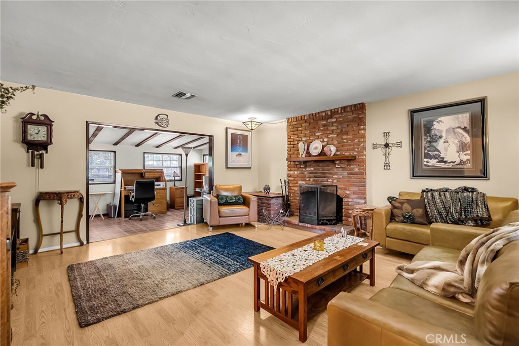 3085 Flanders Road Riverside, CA 92507 - Photo 5 of 23 a living room with furniture a fireplace and wooden floor