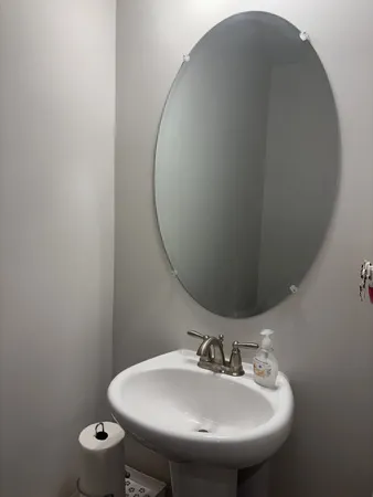 a bathroom with a sink and mirror with toilet