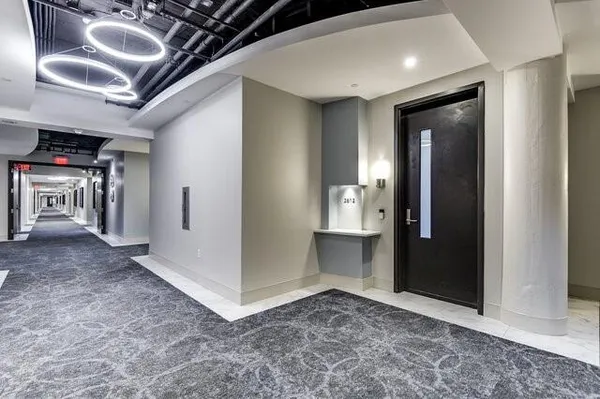 a view of an empty room and a kitchen