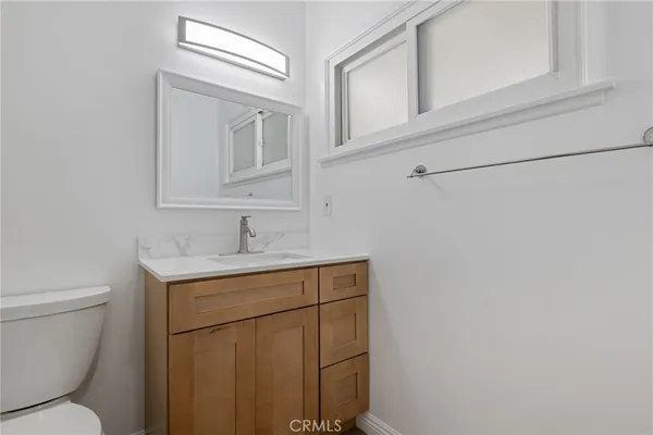 a bathroom with a toilet a sink a vanity and mirror
