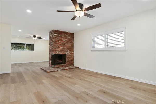 a view of an empty room with a fireplace and a window