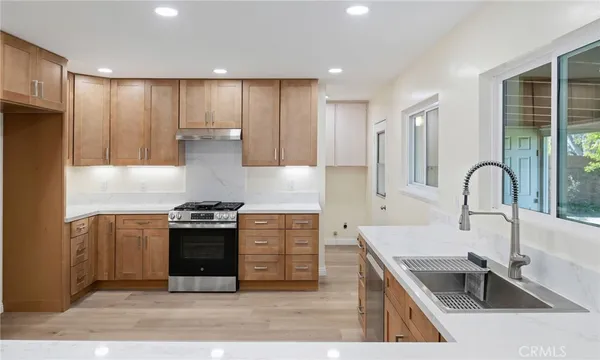 a kitchen with stainless steel appliances granite countertop a sink stove and refrigerator