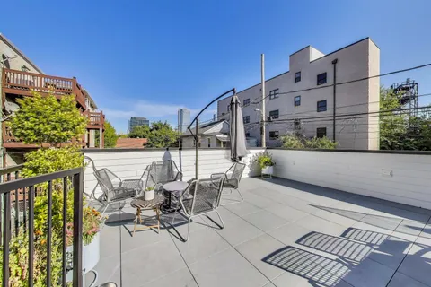 a view of balcony with chairs and iron fence