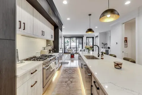 a kitchen with stainless steel appliances granite countertop a sink a stove and a wooden floors