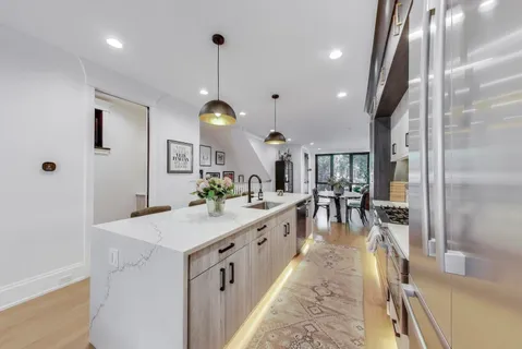 a large kitchen with kitchen island a large counter top space a sink and stainless steel appliances