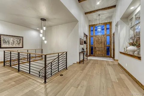 a living room with stainless steel appliances kitchen island granite countertop furniture and a wooden floor
