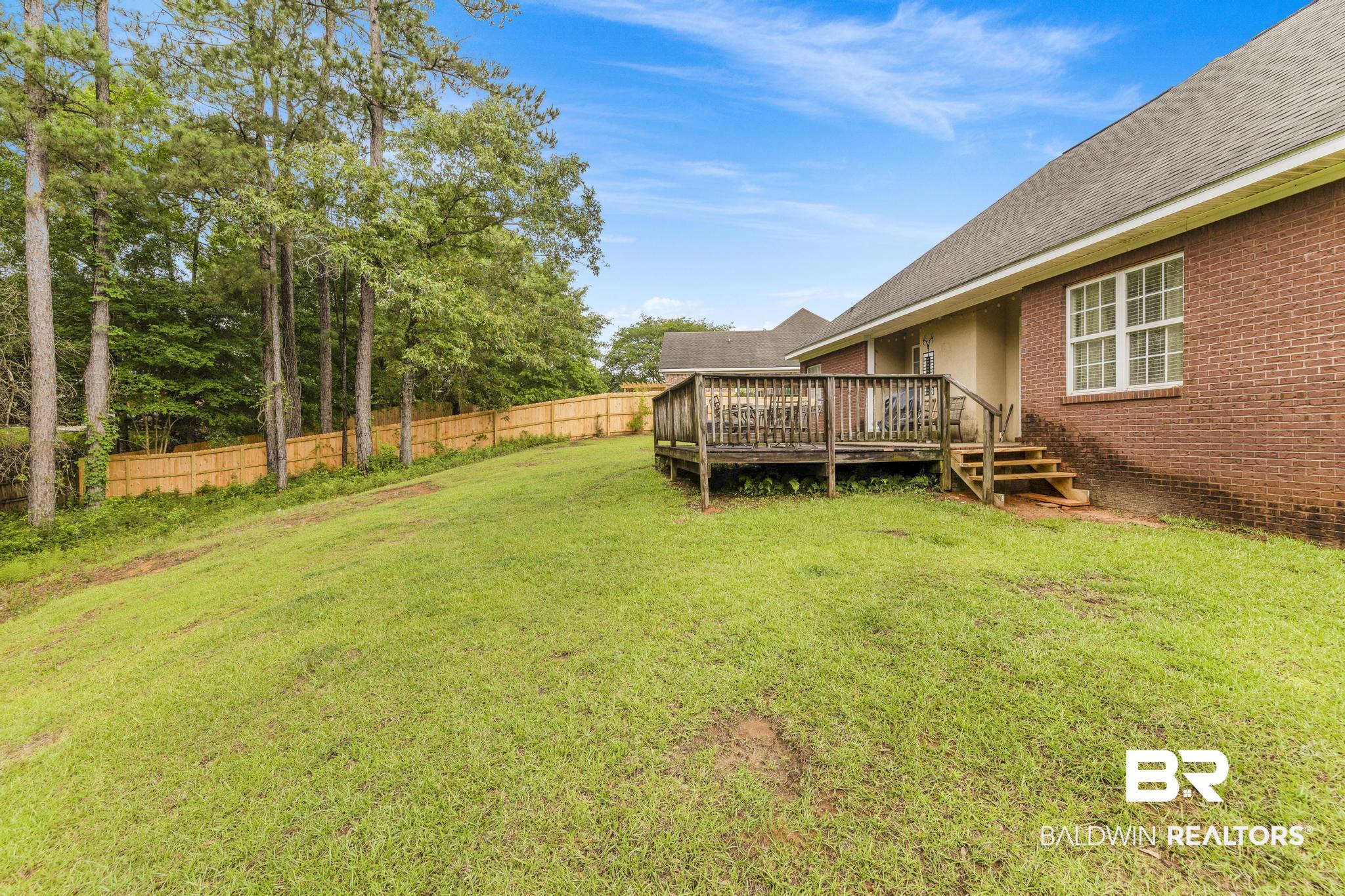 35814 Delvan Lane Bay Minette, AL 36507 - Photo 48 of 53 Spacious backyard featuring a wooden deck with railing, stairs, and a level lawn area