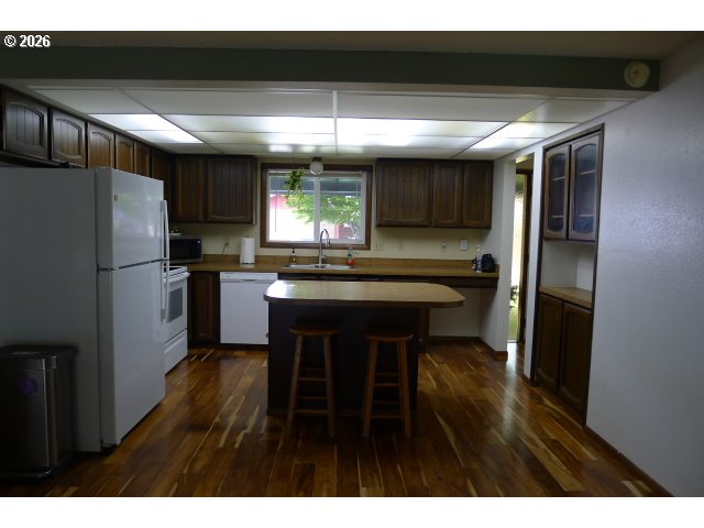 412 Camellia Court Reedsport, OR 97467 - Photo 22 of 48 a kitchen with refrigerator and chairs