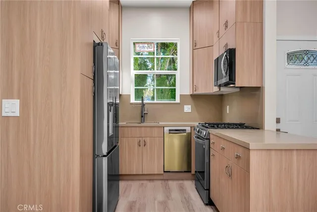 a kitchen with stainless steel appliances granite countertop a stove a sink and a microwave