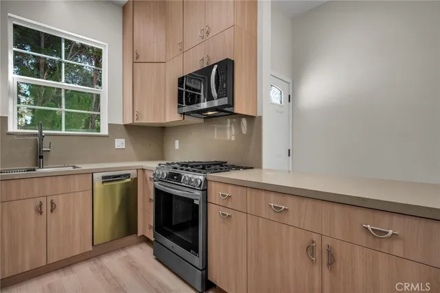 a kitchen with stainless steel appliances granite countertop white cabinets a sink and a stove