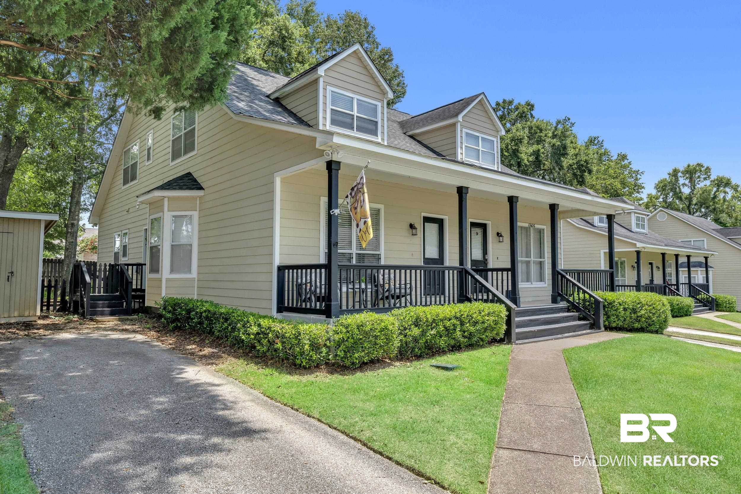 17488 Pandion Ridge, Unit A1 Fairhope, AL 36532 - Photo 3 of 18 Exterior featuring dormer windows, a covered front porch with dark columns and railing, a bay window, and light-colored siding