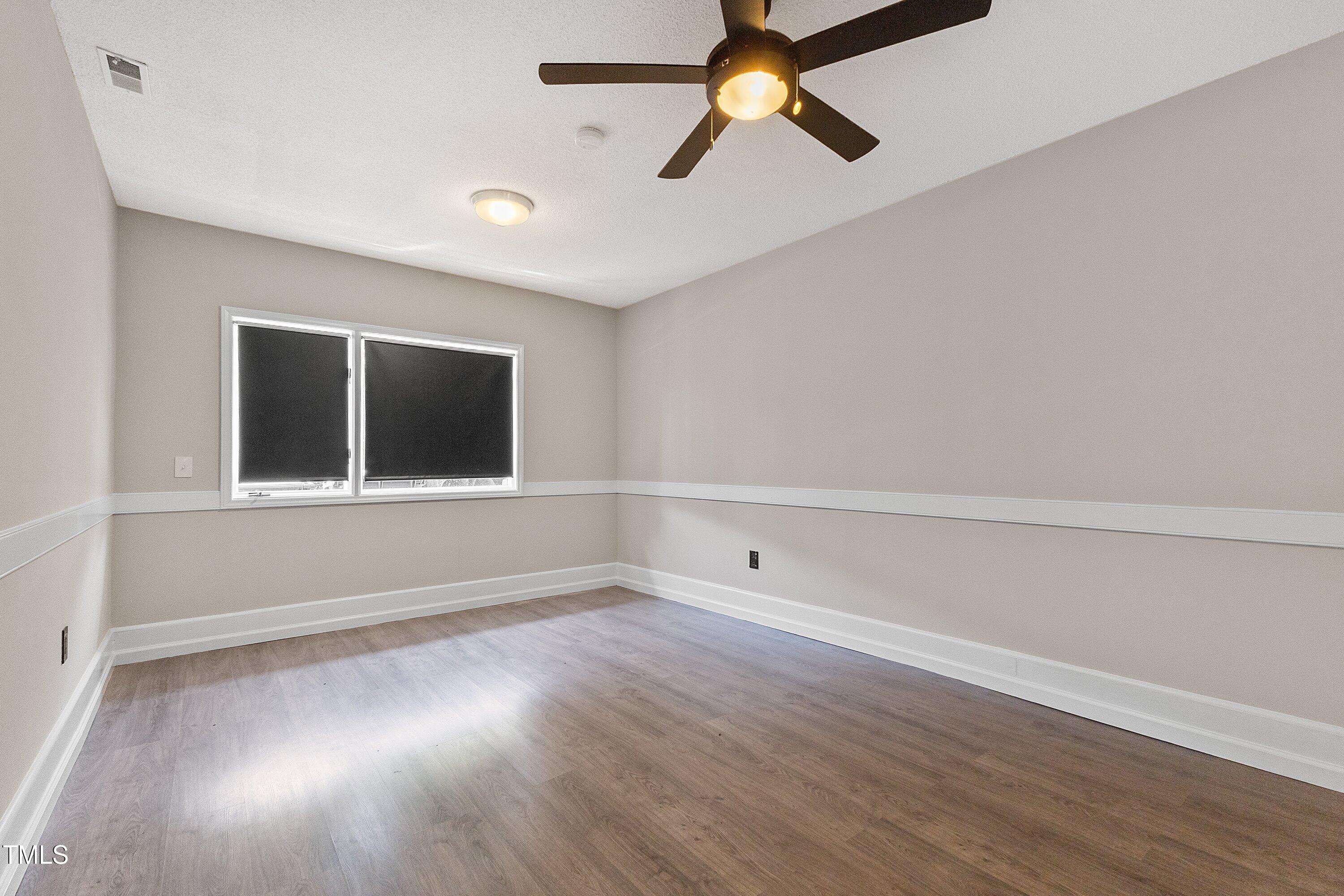 4350 Hunters Club Drive Raleigh, NC 27606 - Photo 12 of 33 wooden floor in an empty room with a window
