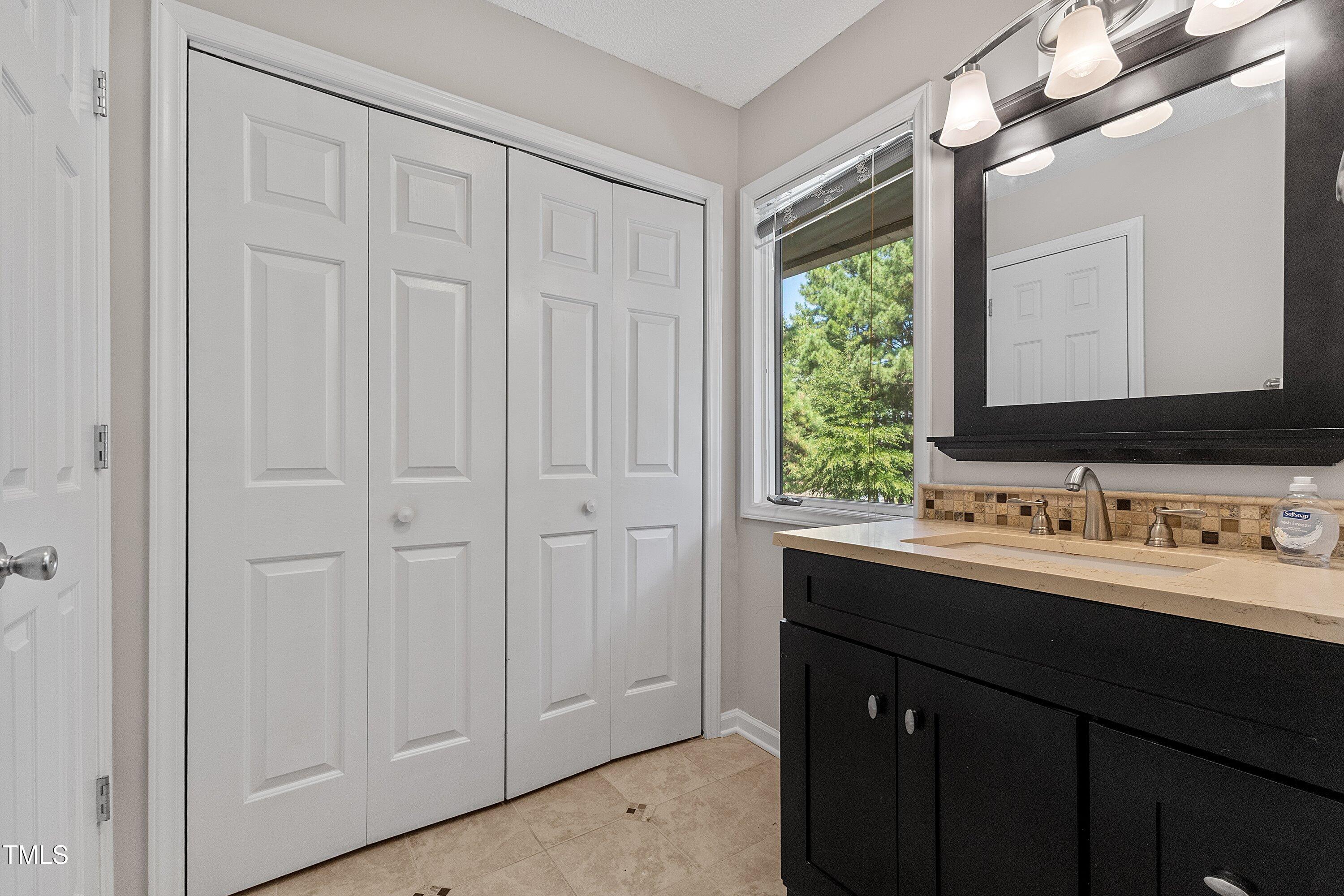 4350 Hunters Club Drive Raleigh, NC 27606 - Photo 22 of 33 a bathroom with a double vanity sink and a mirror