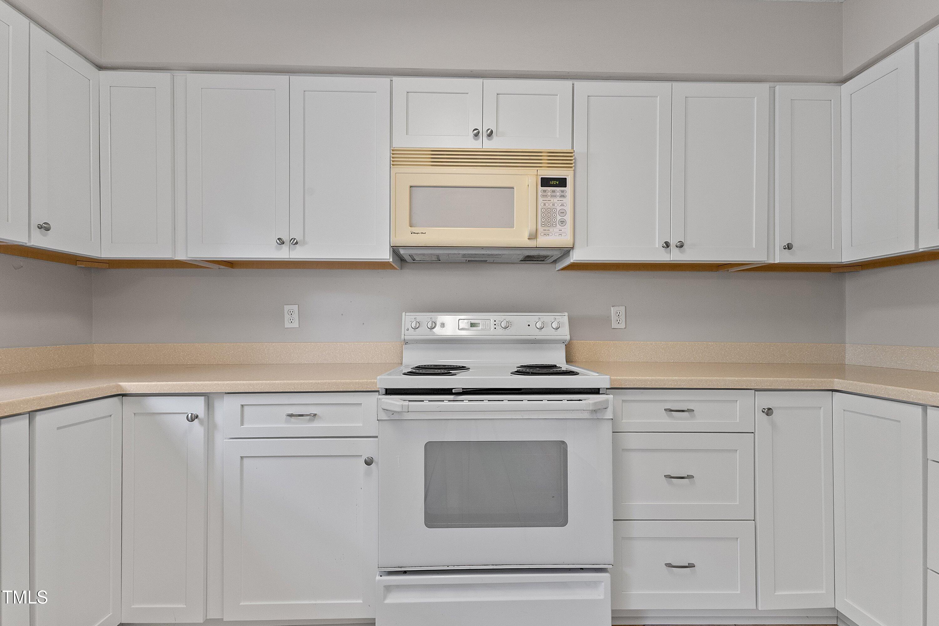 4350 Hunters Club Drive Raleigh, NC 27606 - Photo 8 of 33 a kitchen with granite countertop white cabinets and stainless steel appliances