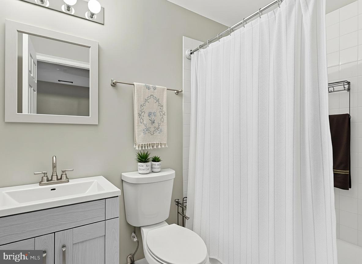 911 South Charles Street, Unit 409 Baltimore, MD 21230 - Photo 8 of 16 a bathroom with a toilet sink and mirror