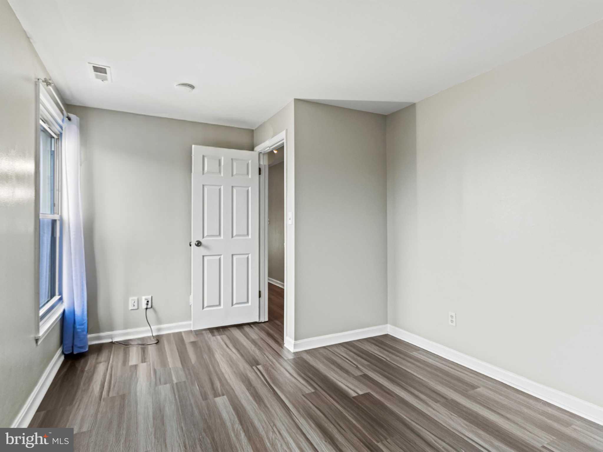 911 South Charles Street, Unit 409 Baltimore, MD 21230 - Photo 10 of 16 a view of an empty room with wooden floor and a window