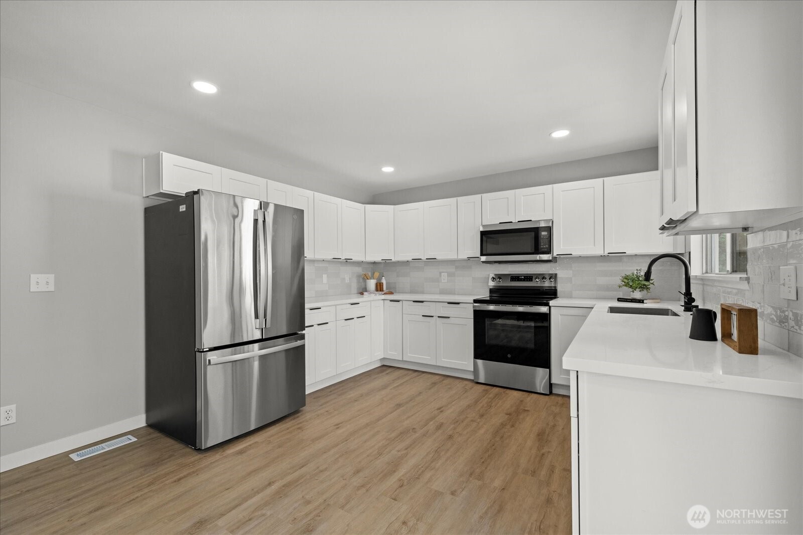16531 120th Avenue Southeast Renton, WA 98058 - Photo 12 of 26 a kitchen with granite countertop a refrigerator stove and wooden cabinets