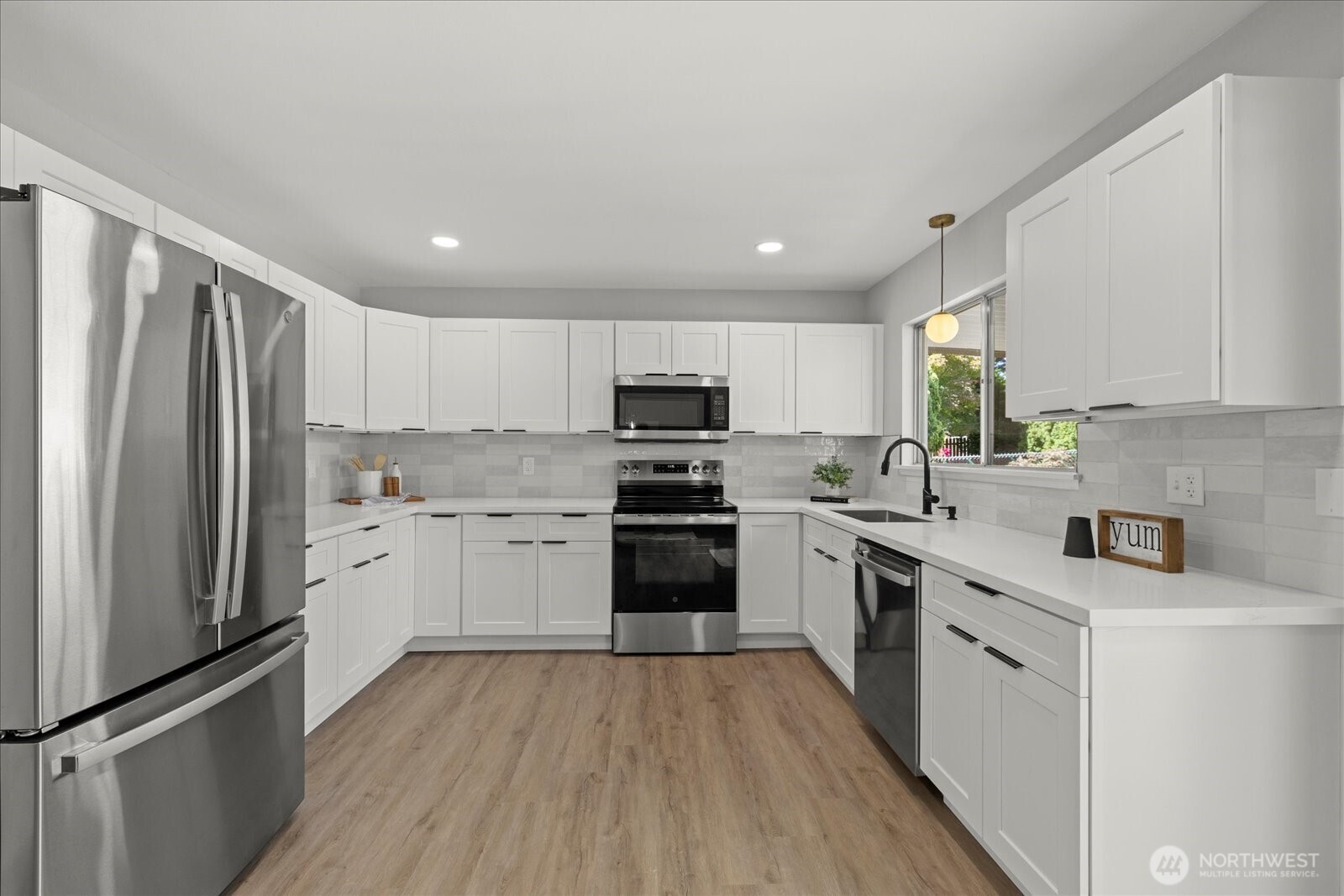 16531 120th Avenue Southeast Renton, WA 98058 - Photo 9 of 25 a kitchen with white cabinets stainless steel appliances and a window