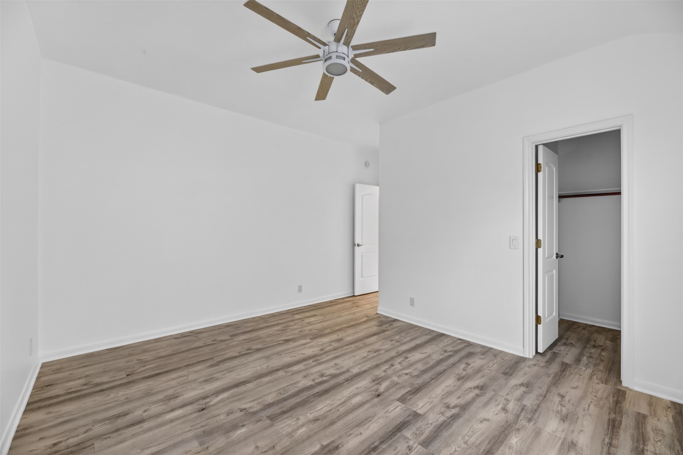 545 Manchester Lane Austin, TX 78737 - Photo 25 of 30 an empty room with wooden floor and a ceiling fan
