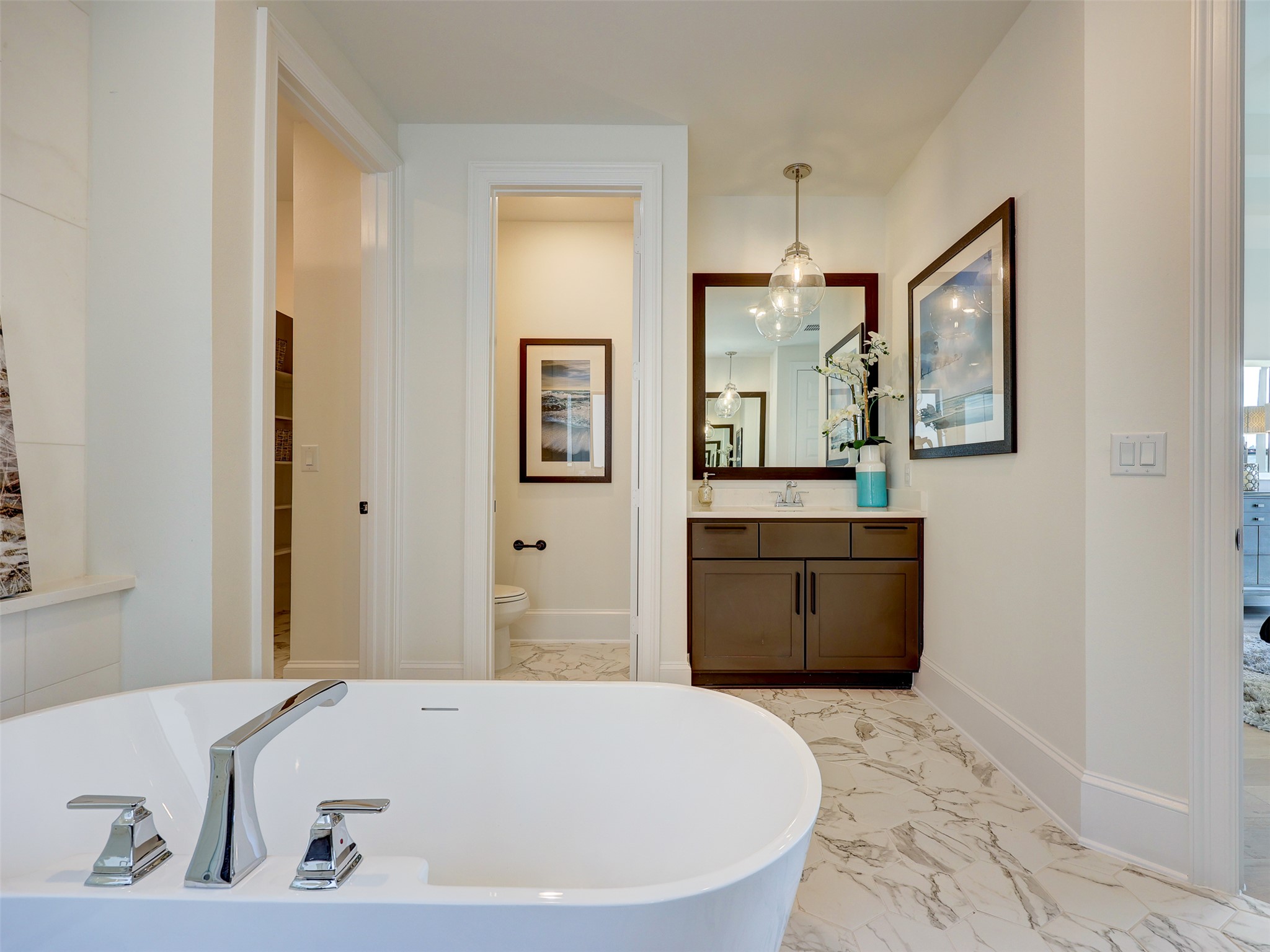 6220 Bower Well Road Austin, TX 78738 - Photo 13 of 28 Luxurious freestanding tub with sleek fixtures, complementing the elegant marble-look flooring and stylish vanity.