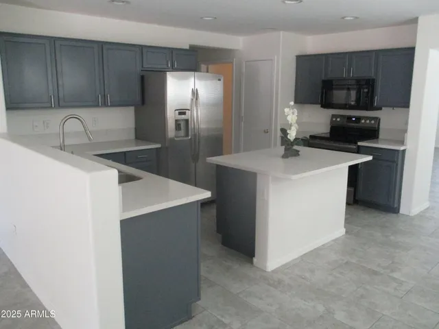 a kitchen with kitchen island a sink stainless steel appliances and cabinets