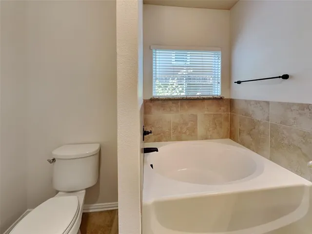 a white bath tub sitting next to a toilet