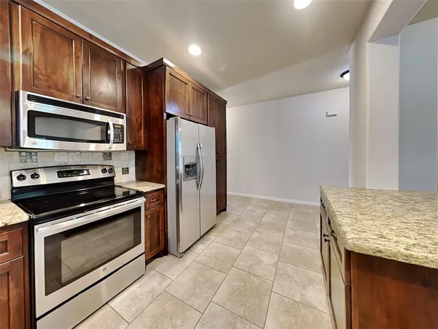 a kitchen with granite countertop stainless steel appliances and wooden cabinets
