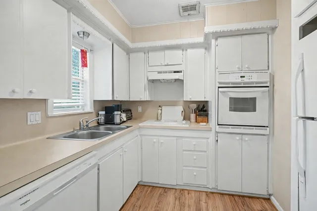 a kitchen with white cabinets and white appliances