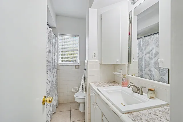 a bathroom with a sink a toilet and a window