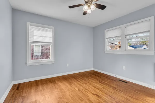 a view of empty room with wooden floor