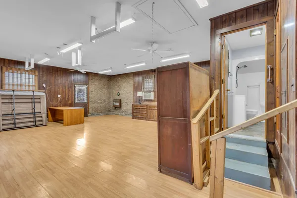 a large kitchen with stainless steel appliances a large counter top a sink cabinets and wooden floor