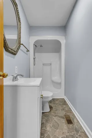 a bathroom with a toilet a sink and mirror