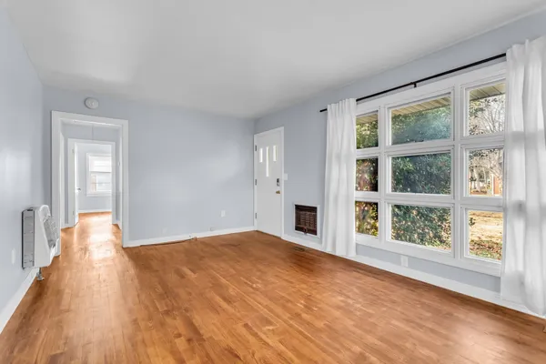 a view of empty room with wooden floor