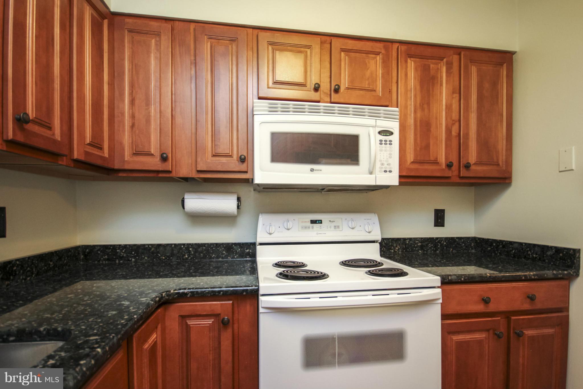 6155 Edsall Road, Unit 6155 Alexandria, VA 22304 - Photo 4 of 29 a kitchen with granite countertop wood cabinets stainless steel appliances and a sink