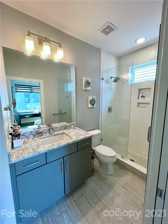 936 Westbrook Drive, Unit A Charlotte, NC 28202 - Photo 23 of 32 a bathroom with a granite countertop sink toilet and shower